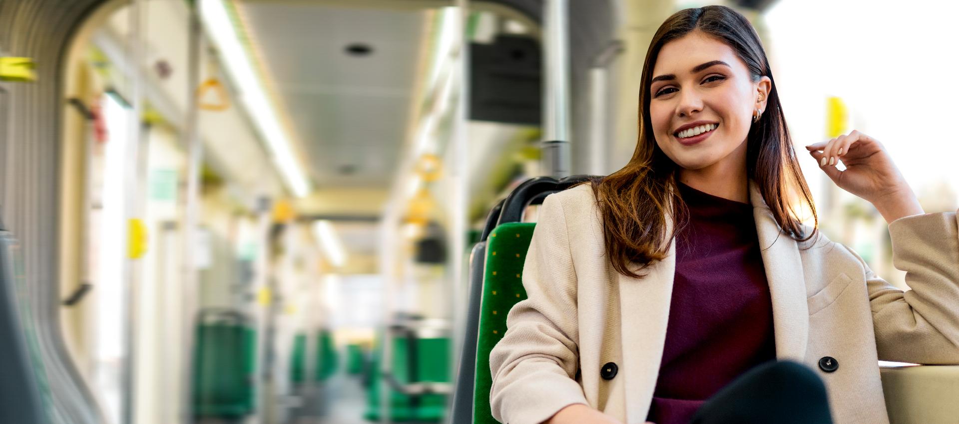 Woman wearing hearing aid smiling in public transport